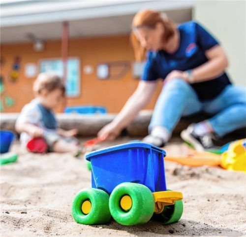Ein Kind spielt mit einer Erzieherin im Sandkasten einer Kita. Foto dpa