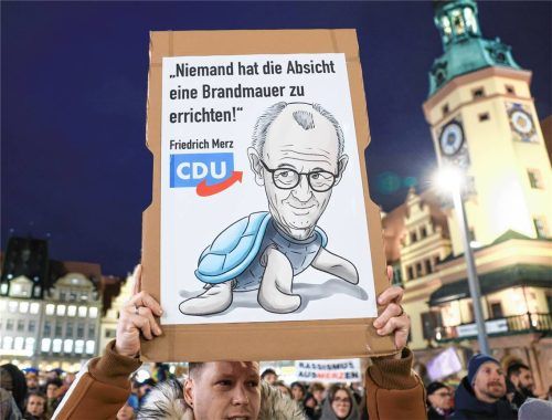 Ein Teilnehmer einer Demonstration unter dem Motto „Das Stadtbild bleibt bunt“ hält auf dem Marktplatz ein Plakat mit der Aufschrift „Niemand hat die Absicht eine Brandmauer zu errichten“. Der Protest richtete sich gegen Aussagen von Bundeskanzler Merz (CDU) zum „Stadtbild“ und zur Migration. Foto dpa