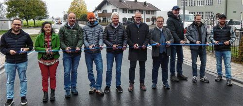 Für die offizielle Freigabe der neu gestalteten Kreisstraße TS3 in Erlstätt wurde auf Höhe des frisch sanierten alten Erlstätter Schulhauses symbolisch ein blaues Band durchschnitten. Mit dabei waren Frank Lehrbach (von links) vom Brothaus Lehrbach, Gitta Schwarz vom Getränkemarkt Schwarz, Gerhard Seehuber von der Tiefbauverwaltung beim Landratsamt Traunstein, der gemeindliche Bautechniker Thomas Dürrbeck, Gerhard Hajer vom Planungsbüro BEGS GmbH, Landrat Andreas Danzer, Bürgermeister Gerhard Wirnshofer, Bernhard Hennes von der Mühlener Gruppe, Andreas Geppert von der ausführenden Firma Erd- und Pflasterbau Schneckenpointner und Christian König von der EG Wolkersdorf. Foto  Müller