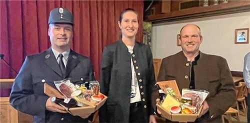 Geschenk als Dankeschön: Christian Schuster (links) ist seit 25 Jahren aktiver Feuerwehrmann bei der Feuerwehr Hittenkirchen. Ebenfalls seit einem Vierteljahrhundert bringt sich Franz Maurer (rechts) als Feldgeschworener ein. Bürgermeisterin Irene Biebl-Daiber bedankte sich für deren jahrzehntelanges Engagement. Foto kirchner