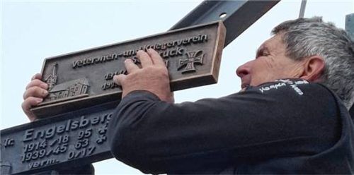 Initiator Franz Schaffner montierte die Gedenktafel am Kampenwandkreuz. Foto Donhauser