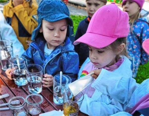 Konzentration am Experimentiertisch: Die jungen Forscher des Hauses für Kinder Vergissmeinnicht mischen ihren eigenen „Regenbogen im Glas“. Foto weber