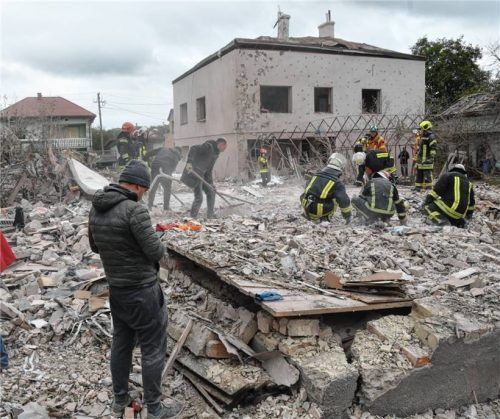 Rettungskräfte suchen in den Trümmern eines zerstörten Hauses nach einem russischen Raketeneinschlag am Stadtrand von Lwiw nach Opfern. Foto dpa