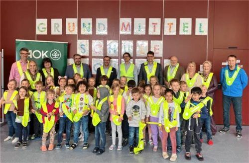 Symbolisch für alle Grundschulen im Landkreis wurden die Sicherheitsüberwürfe an der Grundschule Buchbach von Landrat Max Heimerl (hinten, Fünfter von links) übergeben. Foto aok