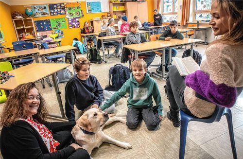 Auch der ausgebildete Schulhund Milo nahm am Vorlesetag teil. Darüber freuen sich neben den Kindern auch Rektorin Margaret Careddu-Bayer (links) und Anja Mörtl (rechts), die Milo betreut. Foto stache