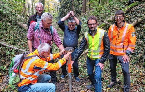 Irschenbergs Bürgermeister Klaus Meixner (Mitte) schlägt den mit den drei Gemeindenamen versehenen Grenzpfahl ein, assistiert vom Feldgeschworenen Konrad Mack (vorne links), Bruckmühls Bürgermeister Richard Richter (Mitte links) und Feldkirchen-Westerhams Bürgermeister Johannes Zistl (Zweiter von links). Beobachtet wird die Aktion von den ADBV-Leitern Falk Brem (hinten links) und Martin Neubauer (rechts). Fotos Baumann
