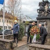 <p>Kranzniederlegung am Kriegerdenkmal durch Christian Mayer und Peter Niedermeier. Trachtenvorstand Andi Neichl (links) sprach nachdenkliche Worte am Mahnmal.</p>