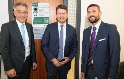 Landrat Otto Lederer (links) und der Leiter des Sachgebiets Ausländer- und Staatsangehörigkeitsrecht, Daniel Herbert (rechts), erläuterten dem bayerischen Innenstaatssekretär Sandro Kirchner erste Erfahrungen mit dem Chatbot MILA.Foto  Landratsamt Rosenheim.