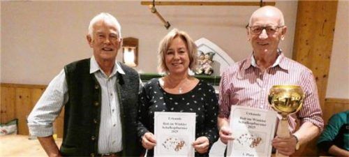 Reit im Winkler Schafkopfmeister 2025 wurden Bernhard Loferer aus Kössen (rechts) bei den Herren und Marion Heistracher aus Reit im Winkl bei den Damen. Organisator und Spielleiter Hans Strohmayer gratulierte den beiden Siegern. Foto  Hauser