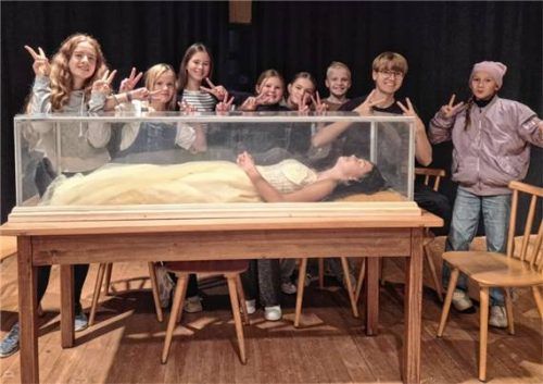 Schneewittchen im prinzessinengemäßen Glassarg inmitten der weiteren jugendlichen Darsteller. Foto re