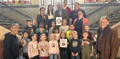 Schüler der ersten Klassen der Luitpoldschule mit (von links) Dr. Stephan Anders, Dr. Brigitte Rossmann, Kathrin Baumeister (St.-Georg-Schule), Bernd Perner, Stefanie Böcklein (Luitpoldschule), Ulrike Nebel (Raphael-Schule B&O), Evi Rummer (Bildungshaus B&O) und Martin Fritsch bei der Übergabe der Reflektoren in der Luitpoldschule.Foto Christoph Lohr, KC Bad Aibling