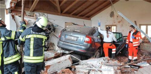 Während der Rettungsdienst die Verletzten versorgt, kümmert sich die Feuerwehr um das Abstützen des Garagendaches. Foto fib/Eß