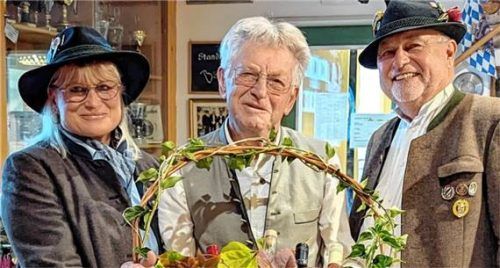 Zweiter Schützenmeister Karlheinz Unger und Böllerreferentin Helga Pflaum überreichen dem Jubilar Wolfgang Rammer einen Geschenkkorb.Foto Gmeiner