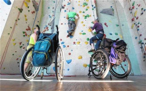 An „Multiple Sklerose“ erkrankte und auf den Rollstuhl angewiesene Männer üben an der Kletterwand. Foto dpa