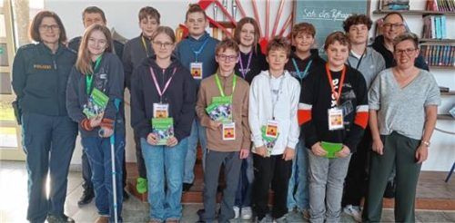 Bei der Übergabe der Schulbuslotsen-Ausweise: (von links, hinten) Polizeioberkommissarin Tina Kain, Polizeioberkommissar Thomas Röttenbacher, Nico Mitterer (7c), Lukas Liebl (7c), Theresa Landgraf (9c), Bastian Spirkl (9a), Vincent Clemente (9c), Schulleiter Claudius Rychlik sowie (von links, vorne) Lilly Ebers (8c), Valentina Orlando (9a), Oliver Horenkamp (7c), Maksymilian Koszarek (7c), Felix Senff (7b) und die Sicherheitsbeauftragte Simone Höfler. Foto  Stettner