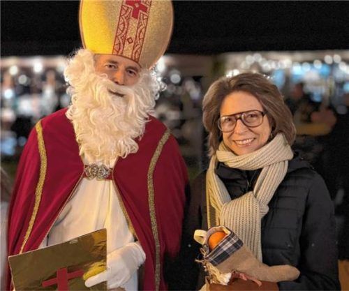 Der heilige Nikolaus besuchte mit Kramperl und Engerln am Sonntagnachmittag den Markt und verteilte gepackte Geschenke an die Kinder und im Herzen jung gebliebene Besucher wie hier Freifrau Peggy von Cramer-Klett. Foto H. REITER