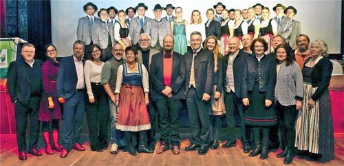 Die Schar der Preisträger mit Kulturreferentin Anke Hellmann (Bühne) und Landrat Otto Lederer (Parkett): Christian Hess (Parkett, Achter von links), Bernadette Pihusch und Clara Neidenberger (Bühne Mitte), der Theaterkreis Wasserburg und D’Mangfalltaler Westerham.Foto  Landratsamt Rosenheim.