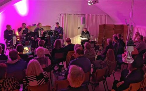 „kreiz & quer“ sitzt auf der Bühne, Reinhard Gampe am Lesepult. Foto Wagner