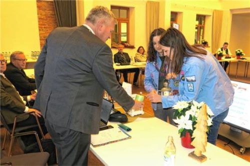 Lena Köferler und Johanna Atzinger (rechts) von den St.-Georgs-Pfadfindern zündeten für Bürgermeister Richard Richter das Friedenslicht aus Bethlehem an. Foto Baumann