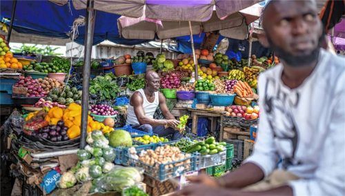 Männer sitzen am Gemüsemarkt in der Wirtschaftsmetropole Lagos in Nigeria. Foto dpa