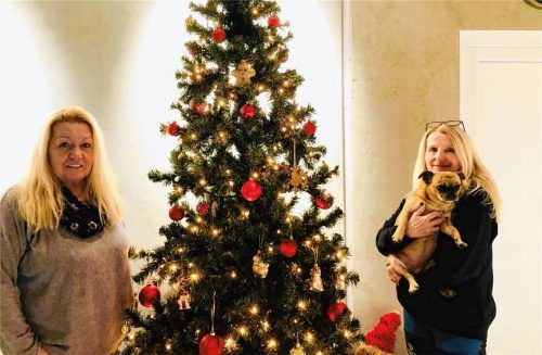 Manuela Gyimes (links) und Gaby Irber vom Tierheim Waldkraiburg mit Hündin Stella vor dem Weihnachtsbaum. Zu Weihnachten sollten aber Tiere nicht verschenkt werden. Foto König