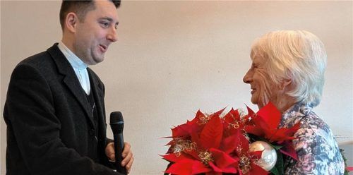 Marianne Kreuz (Lindl) erhält von Pfarrer Konrad Roider einen Blumenstrauß. Foto re
