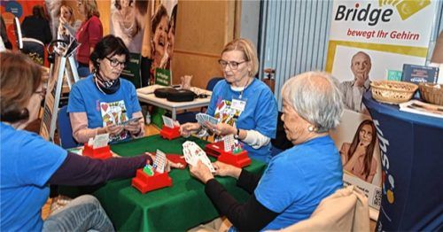 Mitten im bunten Treiben der Seniorenmesse im KuKo Rosenheim saßen Bridge-Spieler hoch konzentriert an ihren Spielkarten, während zahlreiche Messebesucher stehen blieben, und sich interessiert nach dem Spiel erkundigten. Foto .Steffenhagen