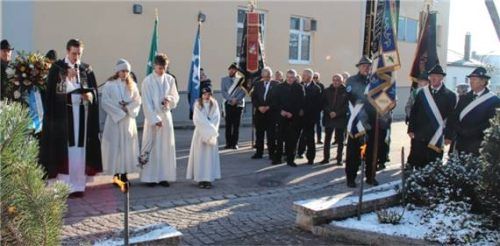 Pfarrer Andreas Kolb mit den Ministranten und den Kameraden am Kriegerdenkmal. Foto albersinger
