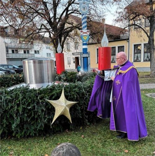 Pfarrer Florian Regner segnete den großen Adventskranz und entzündete die erste Kerze. Foto stettner