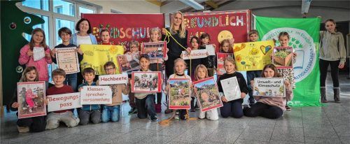 Schüler der Grundschule Reitmehring zeigen verschiedene Aktivitäten mit Schildern auf. Im Hintergrund links Schulleiterin Helga Block und in der Mitte Elternbeiratsvorsitzende Dr. Ursula Winkler-Budenhofer. Foto Rieger
