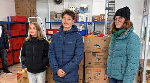 Zwei Schüler vom LSH und Lisa Schwaben, Teamleiterin bei der Tafel, vor den prall gefüllten gespendeten Kisten. Foto  Wunderlich