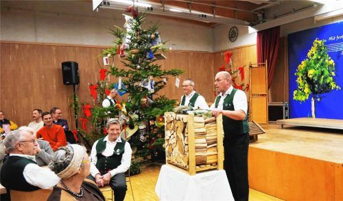 Auktionator Christian Axmann (rechts) beim Versteigern eines Ster Brennholzes an Interessierte.Foto Wastl