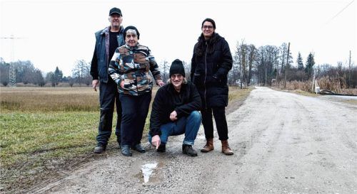 Das ist nur eines von zahlreichen Schlaglöchern in dem Weg zu ihren Häusern: Michael und Angelika Haberl, Günther Serschen und Tanja Liebl-Gschwind (von links) wollen endlich eine Lösung für den Moosschneiderweg in Polling. Foto  Jörg Eschenfelder