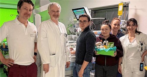 Der kleine Henri liegt geschützt im Inkubator auf der Kinderintensivstation. Fest an seiner Seite stehen die Eltern Maximilian und Jutta Stadler sowie das geburtshilfliche Team, das mit Geschenk und einem kleinen Kuschel-Teddybären gratulierte (von links) PD Dr. Hendrik Jünger (Chefarzt Klinik für Kinder- und Jugendmedizin), PD Dr. Andreas Schnelzer (Chefarzt Klinik für Gynäkologie und Geburtshilfe), Stephanie Kogler (Hebamme, Zweite von rechts) und Domenique Susca (Ärztin Geburtshilfe,rechts).Foto romed