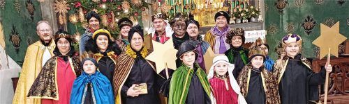 Die ausgesandten Sternsinger mit Diakon Heiko Jung (links) und Burgi Häckel (oben rechts) vor dem Altar der Pfarrkirche St. Nikolaus.Foto Giesen