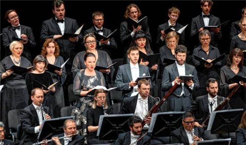 Die Solisten standen inmitten der vereinigten Chöre: (vorderste Sängerreihe, von links) Meredith Wohlgemuth, Manuela Leonhartsberger, Matteo Ivan Rašic und Lukas Enoch Lemcke. Foto SCHEFFOLD MEDIA