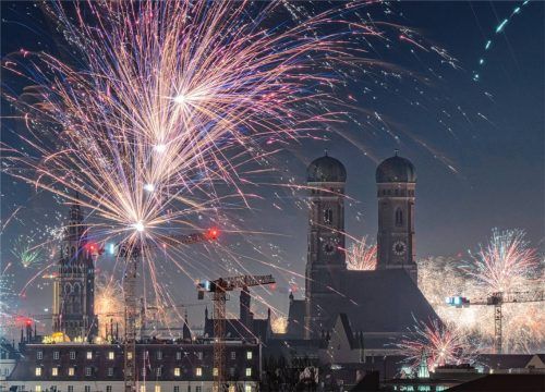 Feuerwerksraketen erleuchten in der Silvesternacht den Himmel über der Münchner Innenstadt, in der die beiden Türme der Frauenkirche das Zentrum bilden. Foto dpa