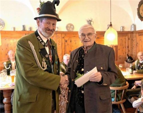 Gebirgsschützenhauptmann Walter Wons (links) gratuliert Ehrenhauptmann Sepp Astner nach Würdigung seiner Verdienste zum 90. Geburtstag und überreicht das Geburtstagsgeschenk der Kompanie.Foto JOHANN WEISS