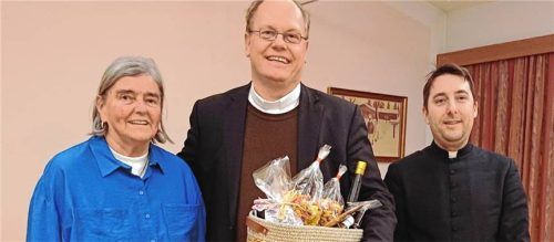 Pfarrvikar Christoph Zirkelbach (Mitte) wird von Pfarrer Konrad Roider und Burgi Häckel mit Geschenken und viel Lob aus der Pfarrgemeinde Übersee verabschiedet. Foto Giessen