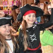 Clowns und Hexen feiern ausgelassen mit Mama und Papa