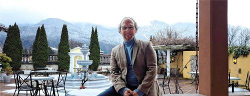 Durchstarten nach der Winterpause: Alexander Winkler, den Garten der Residenz Winkler und die Kampenwand im Rücken. Foto Michael Weiser