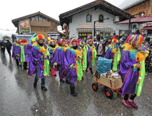 Eine Truppe Clowns ist bunt unterwegs.