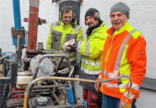 Mit schwerem Gerät treiben Panagiotis Kostamenas (links) und sein Kollege Nico Kloß Rammsonden im Umfeld der Unterlauser Kirche in den Boden. Kirchenpfleger Josef Stahuber (rechts) beobachtete die Arbeiten. Foto Kotter