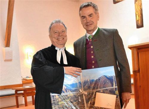 Präsent als Dank: Ein Bild vom Achental übergibt Marquartsteins Bürgermeister Andreas Scheck an Pfarrer Rainer Maier. Foto Wunderlich