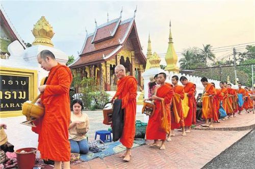 Tradition & Attraktion: der Almosengang der Mönche in Luang Prabang (gr. F.). L.: Andacht in der Pak- Ouv-Höhle. Fotos Picture Alliance/dpa/Carola Frentzen