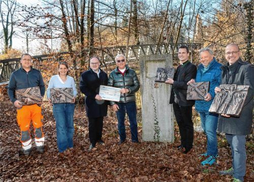 Bürgermeister Andreas Friedrich (Dritter von links) erhielt von dem stellvertretenden Stiftungsrats-Vorsitzenden Gerhard Ruf (Vierter von links) den symbolischen Scheck, der zum Nachguss der Stelen verwendet wird. Die Votivtafeln in den Händen halten: (von links) Bauhofleiter Klaus Kollmannsberger, Kunstgießerei-Inhaberin Nicola Kirchner, Pfarrer Philipp Werner, Kassier Walter Kofler und Vorsitzender Stefan Huber von der Kolpingsfamilie.Foto  Berger.