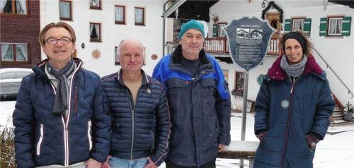 Das Anwesen „Der Wirtschmied“ neben der Pfarrkirche ist eines der ältesten Gebäude in der Gemeinde Inzell und dürfte dem Baustil nach um das Jahr 1600 erbaut worden sein. Heimatpfleger Markus Preinfalk (von links) und Zweiter Vorsitzender des „Verkehrs- und Heimatvereins“, Herbert Öttl, überreichten ein Hofschild mit der Geschichte des Hauses an die Eigentümer Franz und Maria Kamml. Foto Wegscheider