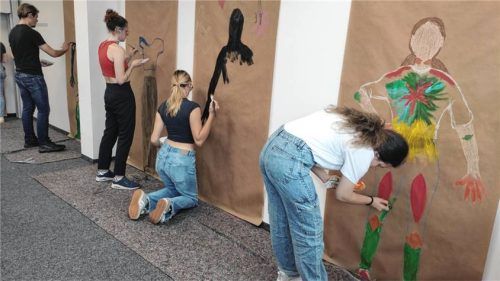 Die Studierenden am Campus Mühdorf am Inn erstellen im Selbsterfahrungsseminar mit Carolin Behr ein Körperbild.