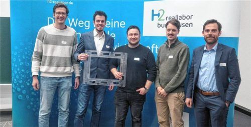 Die Vertreter des Rohrdorfer Net Zero Emission-Teams mit dem Kunststoffrahmen, der ein Element der geplanten Elektrolysezelle ist und zeigt, wie groß die Zelle wird, die im Herbst in Betrieb gehen soll. Zweiter von links ist Projektleiter Alexander Beck. Foto Re
