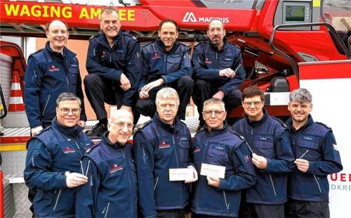 Feuerwehrleute des Landkreises Traunstein posieren vor einem Feuerwehrfahrzeug während einer Typisierungsaktion zur Bekämpfung von Leukämie. Foto hob